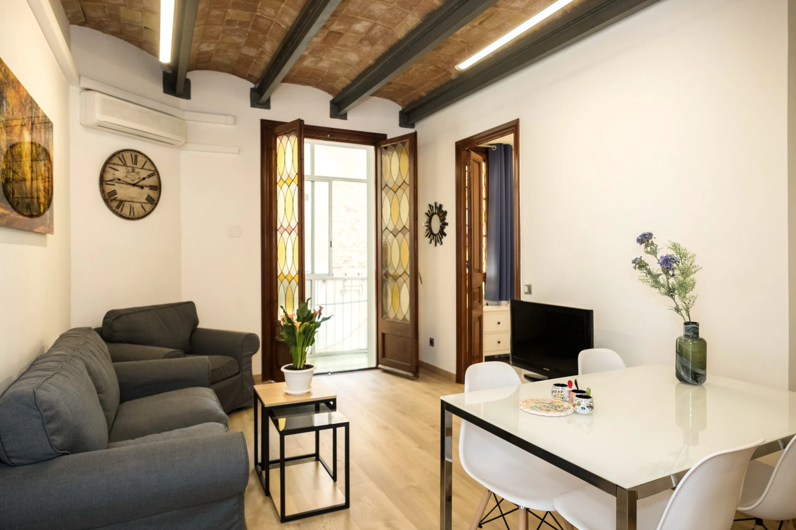 Salón luminoso del apartamento stayinbcn con ventanas de vidriera, Eixample Barcelona